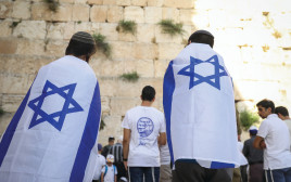 מתפללים בכותל עטופים דגלי ישראל (צילום: נעם ריבקין פנטון, פלאש 90)