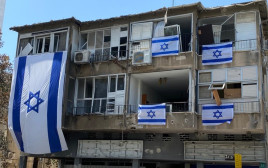 דגלי ישראל על הבניין שנפגע מרקטה בר"ג (צילום: אבשלום ששוני)