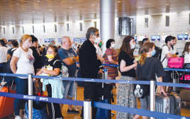 נוסעים ממתינים בנתב"ג עם מסכות (צילום: פלאש 90)