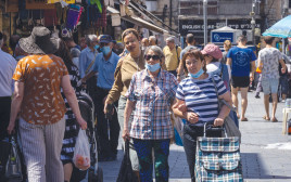 אנשים מסתובבים ברחוב עם מסיכות (צילום: אוליבייה פיטוסי, פלאש 90)