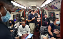 אנשים עם מסכה ברכבת התחתית בלונדון לאחר הסרת ההגבלות (צילום:  Martin Pope/Getty Images)