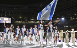 חנה קנייזבה-מיינקו ויעקב טומרקין נושאים את דגל ישראל בטוקיו 2020 (צילום: Matthias Hangst/Getty Images))