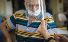 אדם מבוגר מתחסן נגד הקורונה (צילום: יונתן זינדל, פלאש 90)