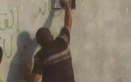 מפגין פלסטיני מכוון אקדח דרך גדר רצועת עזה (צילום: ללא)
