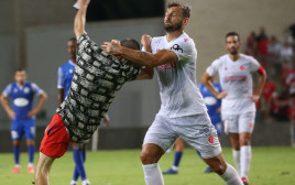 אדי גוטליב, שחקן הפועל תל אביב, ליד אוהד שתקף אותו (צילום: אודי ציטיאט)