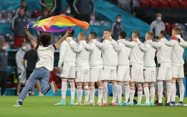 אוהד נבחרת גרמניה עם דגל הגאווה ליד שחקני נבחרת הונגריה (צילום: רויטרס)