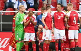 שחקני נבחרת דנמרק מרטין ברייתווייט, יוסוף פאולסן, קספר שמייכל עומדים סביב כריסטיאן אריקסן (צילום: רויטרס)