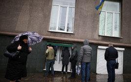 ממהרים למשוך כסף מכספומטים באוקראינה לאחר הודעת פוטין (צילום: REUTERS/Carlos Barria)