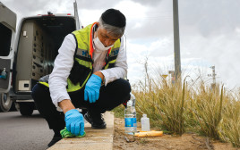 מתנדב זק''א מנקה את זירת הפיגוע בבאר שבע (צילום: אוליבייה פיטוסי, פלאש 90)