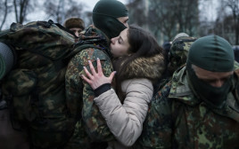 חייל אוקראיני נפרד מבת זוגו לפני שיוצא לקרב, למצולמים אין קשר לנאמר בכתבה (צילום: רויטרס)