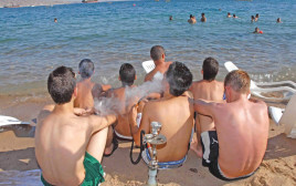 בני נוער מעשנים נרגילות בחוף הים באילת (צילום: יהודה בן יתח)