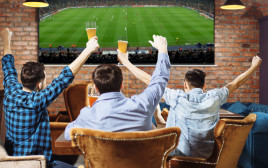 שלושה חברים רואים כדורגל בטלוויזיה (צילום: ShutterStock)