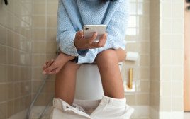 גולשים בנייד כשאתם בשירותים? אתם מעבירים חיידקי מעיים לכל מקום (צילום: אינג'אימג')