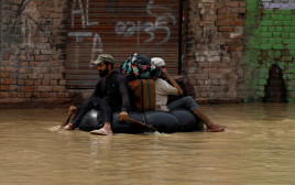 נמלטים מבתיהם שהוצפו בפקיסטן (צילום: רויטרס)