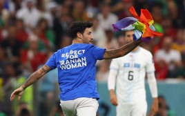 אוהד פורץ למשחק של פורטוגל-אורוגוואי עם דגל הגאווה (צילום: רויטרס)