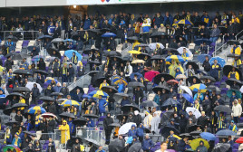 אוהדי מכבי תל אביב עם מטריות, גשם, אצטדיון בלומפילד (צילום: לירון מולדובן)