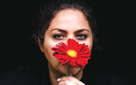 אישה עם פרח מתוך תערוכה העוסקת באלימות במשפח (צילום: צופיה שלסקי)