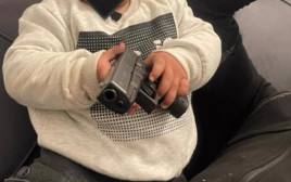פעוט מחזיק באקדח (צילום: דוברות המשטרה)