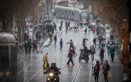 אנשים ברחוב בגשם בירושלים (צילום: אוליביה פיטוסי, פלאש 90)
