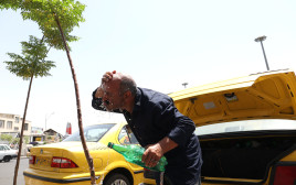 נהג מונית איראני מקרר את עצמו בעקבות החום הכבד (צילום: Majid Asgaripour/WANA (West Asia News Agency) via REUTERS)