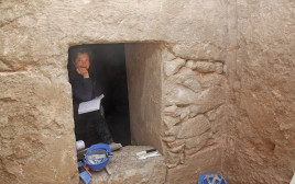 ליאת עוז בכניסה למערת הקבורה (צילום: יותם אשר, רשות העתיקות)