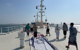 תיירים דורכים על דגלי ישראל וארצות הברית שנפרשו במרכז ה-"GALAXY LEADER" (צילום: REUTERS/Khaled Abdullah)