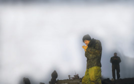 חייל מילואים מדליק סיגריה 24 בינואר 2024 (צילום: מיכאל גלעדי, פלאש 90)