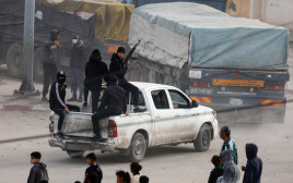 חמושים משתלטים על משאיות סיוע בעזה (צילום: REUTERS/Mohammed Salem)