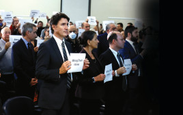 ג'סטין טרודו, מרים שלט עם המשתתפים במהלך עצרת פרו-ישראלית באוטווה, קנדה, 9 באוקטובר 2023 (צילום: רויטרס)