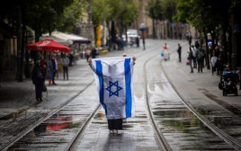 עם דגל ישראל בצפירה ביום הזיכרון לשואה ולגבורה בירושלים (צילום: יונתן זינדל, פלאש 90)