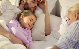 ילדה ישנה עם ההורים אילוסטרציה (צילום: אינגאימג')