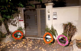 זרי הפרחים שהונחו בכניסה לביתו של יולי אדלשטיין (צילום: פורום "מתגייסים לאחדות")