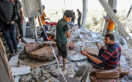 תושבים פלסטינים בבית שנהרס בתקיפת צה"ל בעזה (צילום: עבד ראחים חטיב, פלאש 90)