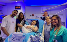  המשפחה המאושרת וצוות חדר לידה בשיבא, התינוק הראשון בשנת תשפ״ה (צילום: דוברות שיבא)