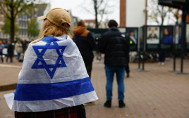אישה עטופה בדגל ישראל באמסטרדם (צילום: רויטרס)