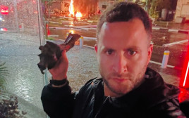 גיא הוכמן עם שבר יירוט ליד ביתו (צילום: מתוך אינסטגרם)