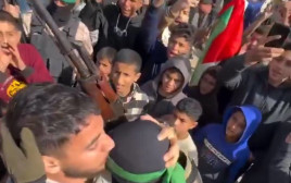 תומך חמאס מנשק את המחבל בנקודת איסוף החטופות (צילום: רשתות ערביות)