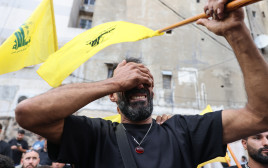 תושב לבנון עם דגל חיזבאללה (צילום: ANWAR AMRO/AFP via Getty Images)