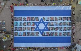 06:29 דגל ישראל עם תמונות החטופים והחטופה בכיכר החטופים (צילום: יאיר פלטי)