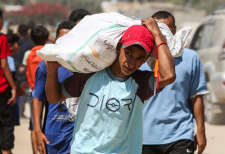 פלסטיני סוחב סיוע הומניטרי (צילום: רויטרס)