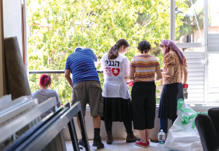 מתנדבים מסדרים דירה שנפגעה מטיל איראני  (צילום:  דור פוזאלו)