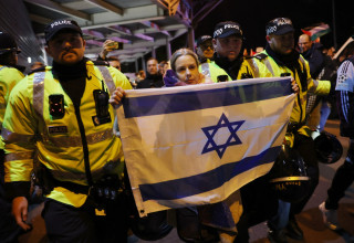 אוהדת עם דגל ישראל מורחקת מאזור וילה פארק לפני המשחק של מכבי תל אביב נגד אסטון וילה (צילום: רויטרס)