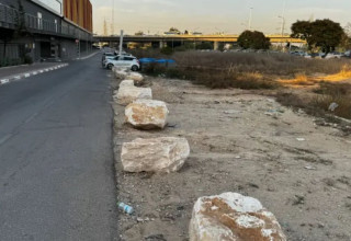 אבנים על חניית עפר מול קניון אשדוד, תחנת הרכבת אשדוד (צילום: דן עזרא)