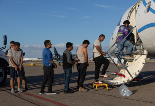 מהגרים מועלים על מטוס  (צילום: רויטרס)
