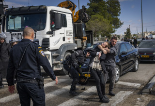 שוטר עוצר מפגין חרדי שחסם את הכביש  (צילום: חיים גולדברג פלאש 90)