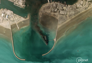 ספינה איראנית עולה באש בנמל באנדר עבאס (צילום: PLANET LABS PBC/Handout via REUTERS)