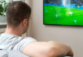 גבר צופה במשחק כדורגל בטלוויזיה (צילום: ShutterStock)
