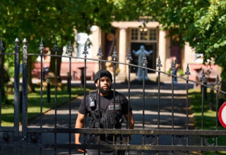 מאבטח במתחם הכת "דת אחמדיה של שלום ואור" בצ'שייר בבריטניה (צילום: צילום מסך The Guardian)