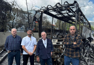 משפחת סגל ובן עמי (מימין) ליד אוטובוס החברה שהוצת בחודש שעבר (צילום: ללא)