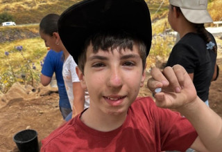 התלמיד אלון הורביץ והאבן הנדירה (צילום: צוות חפירות כורזים)